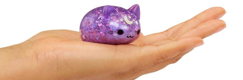 Purple glitter kawaii cat Moj Moj crunch squishy toy resting on an open palm to show size