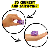 Hand squeezing and holding a small purple glitter kawaii cat Moj Moj crunch squishy toy
