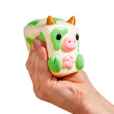 Hand squeezing MushyKinz Chip the Cow taba squishy, soft sensory fidget toy