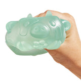 Adult hand squeezing a translucent mint green MushyKinz Jelleez cow squishy, showing its soft firm squish