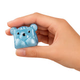 A hand holding a small, translucent light blue bear-shaped squishy toy against a plain white background.