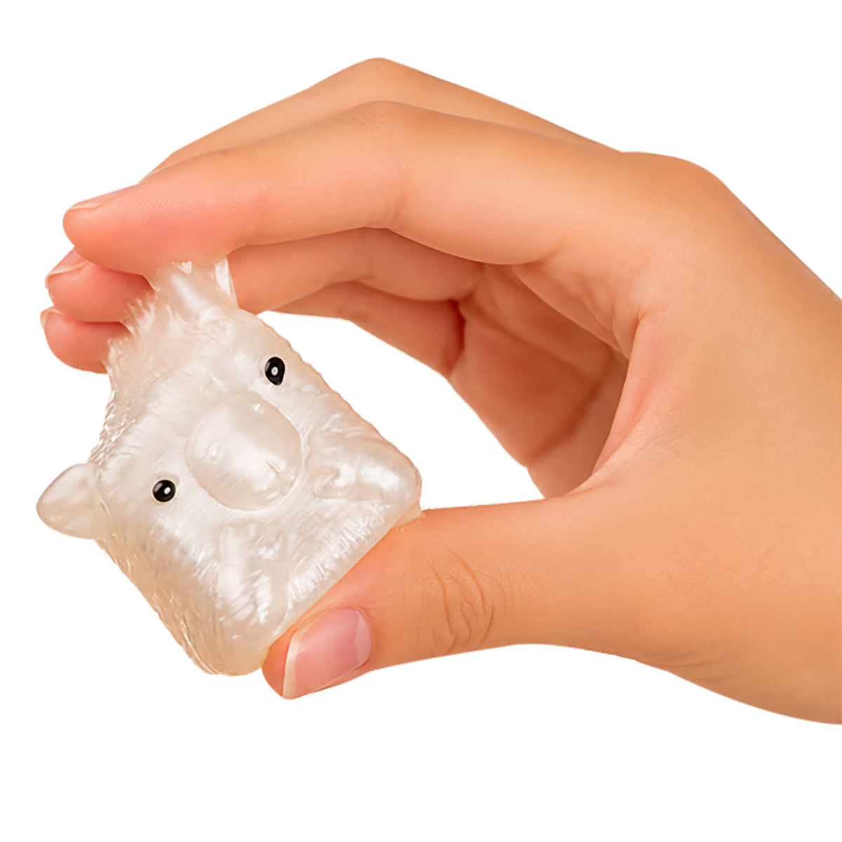A hand holding a small, translucent, animal-shaped squishy toy with black eyes, shown against a plain white background.