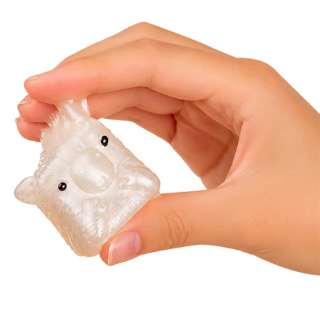 A hand holding a small, translucent, animal-shaped squishy toy with black eyes, shown against a plain white background.