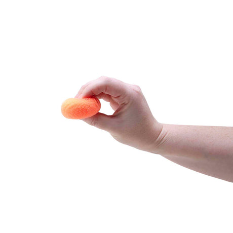 Hand squeezing an orange Nee Doh Teenie Fuzz Ball between thumb and fingers
