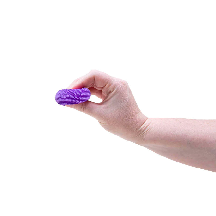 Hand squeezing a purple Nee Doh Teenie Fuzz Ball flat between fingers