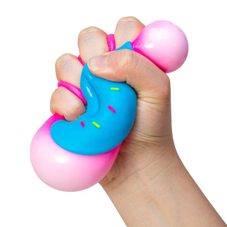 Hand squeezing a blue and pink NeeDoh Dohnut squishy toy showing the satisfying squish deformation