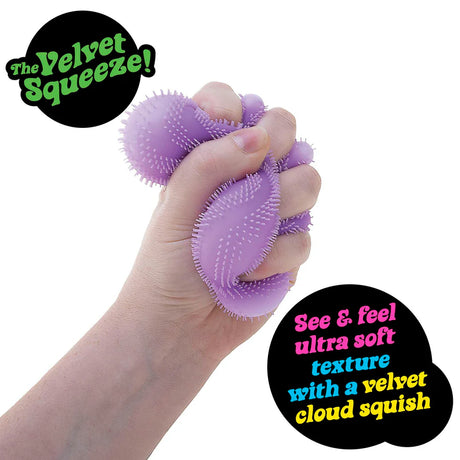 Hand squeezing purple NeeDoh Fuzz Ball Wonder Waves showing the velvet cloud squish deformation