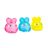 Three NeeDoh Jelly Hops squish bunnies side by side in pink, blue and yellow with glitter detail