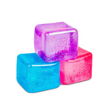 All three Nee Doh Nice Berg Glitter and Glow squish cubes in blue, purple, and pink stacked together on white background