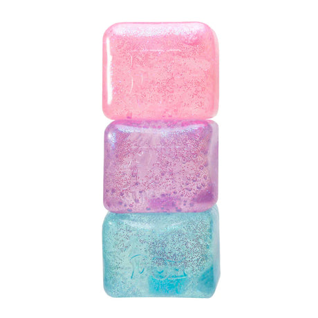 Three NeeDoh Glitter and Glow Nice Cubes stacked in pink, purple and blue showing glitter detail