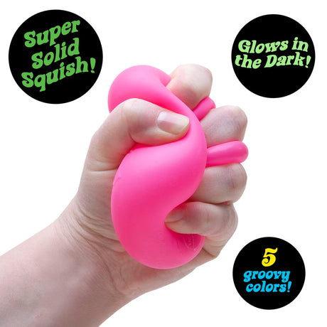 Hand squeezing a pink Nee Doh Nice Cube Glow showing super solid squish texture and deformation