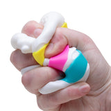 Nee Doh Peace O' Cake squishy sensory toy squeezed in hand, stress relief fidget