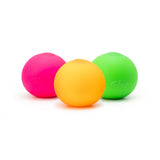 Three neon squish balls in hot pink, orange and lime green displayed together on a white background
