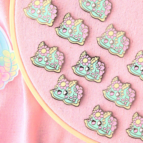 Noodibuns by Evy Benita mint green floral nudibranch enamel pins on pink display