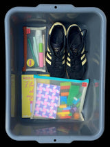 clear storage bin with mesh pouches book adidas trainers and small fidget items