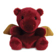 Aurora Palm Pals Aidan Dragon plush — a small deep red dragon with soft golden wings, round ears, and a gentle smiling face, sitting upright against a white background