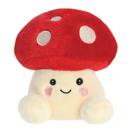 Aurora Palm Pals Amanita Mushroom plush — a red-capped toadstool with white embroidered spots, a cream stem body, pink rosy cheeks, and a happy smiling face
