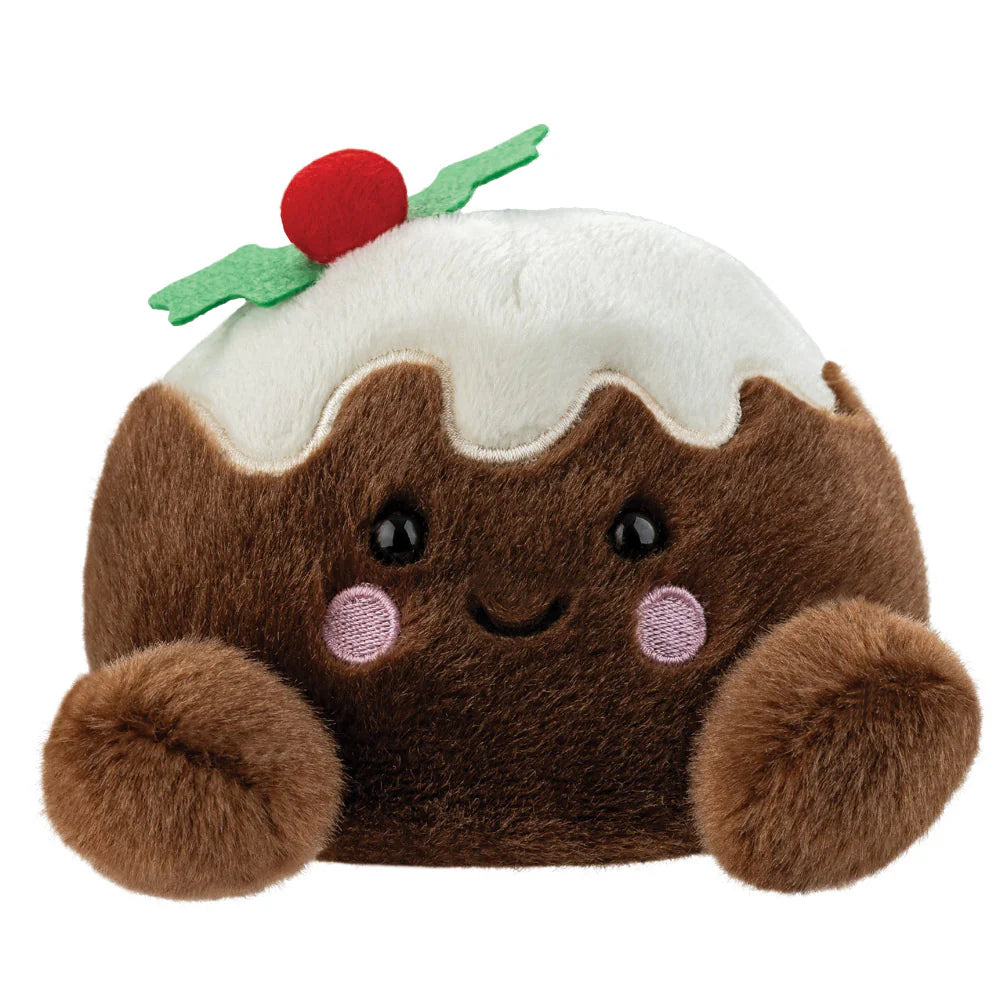 A plush pudding character toy with brown fuzzy body, white frosting, green holly leaves, and a red berry on top, set against a plain white background.