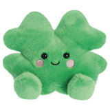 Aurora Palm Pals Chance Clover plush — a bright green four-leaf clover soft toy with a cheerful smiling face, pink embroidered cheeks, and rounded paw-like feet