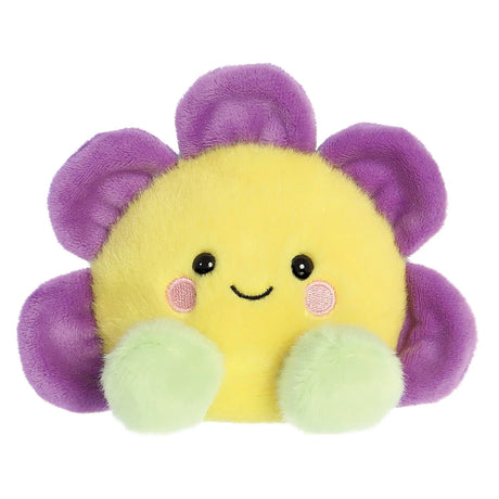 Aurora Palm Pals Fallon Flower plush — a yellow-centred daisy with purple petals, pale green rounded feet, pink blush cheeks, and a cheerful smiling face