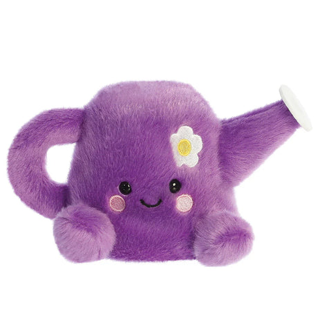 Aurora Palm Pals Flo Watering Can plush — a purple watering can soft toy with a daisy embroidered on the front, a spout, handle, pink cheeks, and a smiling face