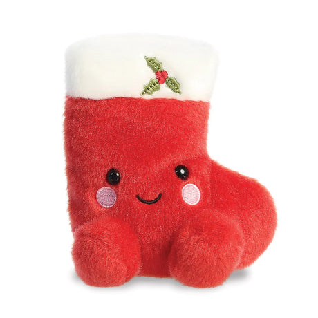 Palm Pals Holly Stocking plush, a small palm-sized stuffed red Christmas stocking with a white fluffy cuff, an embroidered holly and berries motif, pink rosy cheeks, and a smiling face