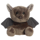 Aurora Palm Pals Luna Bat plush — a dark brown bat soft toy with dark grey fabric wings, rounded ears, a small brown nose, and a compact seated pose against a white background