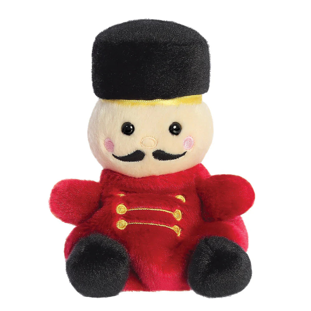 Palm Pals Marius Nutcracker plush, a small palm-sized stuffed nutcracker soldier with a cream face, black embroidered moustache, a tall black hat with gold band, a red uniform with gold embroidered detail, and black feet