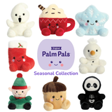 Aurora Palm Pals Seasonal Collection group shot showing eight palm-sized plush characters including Boo Ghost, Cassia Hot Cocoa, Froyo Snowflake, Holly Stocking, Freeze Snowman, Jolly Elf, Oak Acorn, and Skelly Skeleton arranged around the official Palm Pals Seasonal Collection logo
