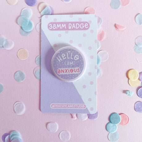 Peachy Lane Studio Hello I Am Anxious badge, lilac, flat lay with pastel confetti