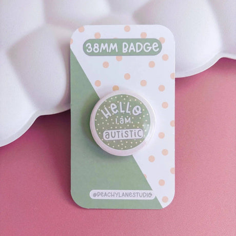 Peachy Lane Studio Hello I Am Autistic badge, sage green, on pink background