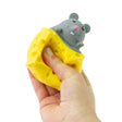 Hand squeezing a yellow cheese wheel squeeze toy causing a grey kawaii mouse to pop out of the top