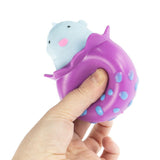 Hand squeezing a purple spotted Peek-A-Boo Octopus squeeze toy causing a blue kawaii face to pop out