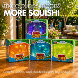 Four boxed Play Hub Squishy Cube fidget toys in purple, orange, blue and green on a wooden table