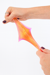 Colorful slime being stretched between two hands on a white background
