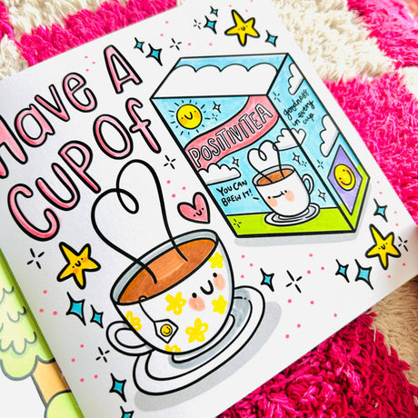 Completed colouring page from The Positivity Colouring Book showing a kawaii cup of tea and Positivitea box illustration