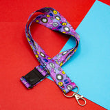 purple lanyard with colourful smiley diamonds clocks and hearts pattern with clasp