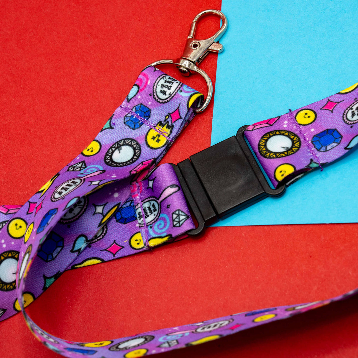 purple lanyard strap with bright smiley diamonds clocks and geometric icons