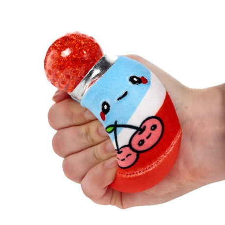 Hand squeezing a red and blue cherry soda can Queasy Squeezie causing red water bead lid to bulge out