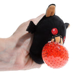 Hand squeezing the red gel bead centre of a Queasy Squeezies bat plush toy