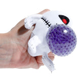 Hand squeezing the purple gel bead centre of a Queasy Squeezies skeleton plush toy