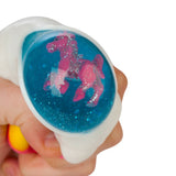 Hand squeezing the rainbow cloud toy revealing a pink glitter unicorn figure floating in the blue glitter water centre