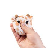 Hand squeezing a kawaii giraffe plush sensory toy showing soft sugar-filled compression