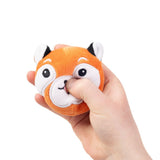 Hand squeezing a kawaii red fox plush sensory toy showing soft sugar-filled compression and white face markings