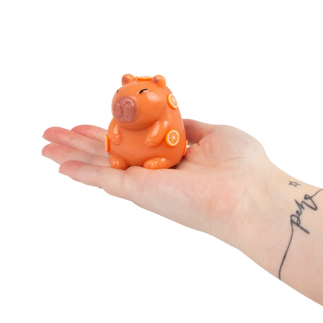 Orange Scrunchems squishy capybara with citrus slice details resting on an open palm