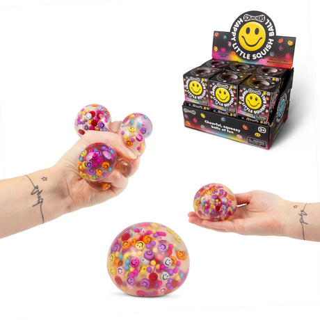 Scrunchems Happy Little Squish Ball display box beside hands squeezing the bead-filled toy