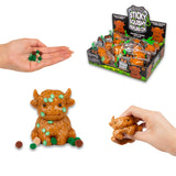 Scrunchems Sticky Squishy Highland Cow shown with sticky leaf pieces, pom-pom balls, and retail display box