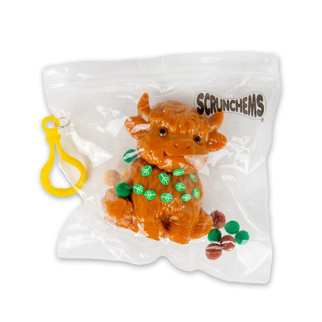 Scrunchems Sticky Squishy Highland Cow in sealed bag with sticky pom-pom balls and yellow clip hanger