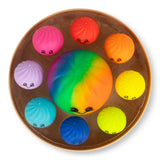 Nine kawaii Scrunchems dumpling squishy toys arranged inside an open bamboo-style steamer box