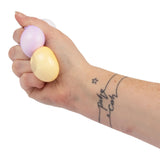 Hand holding lilac and yellow mini kawaii dumpling squishy toys together